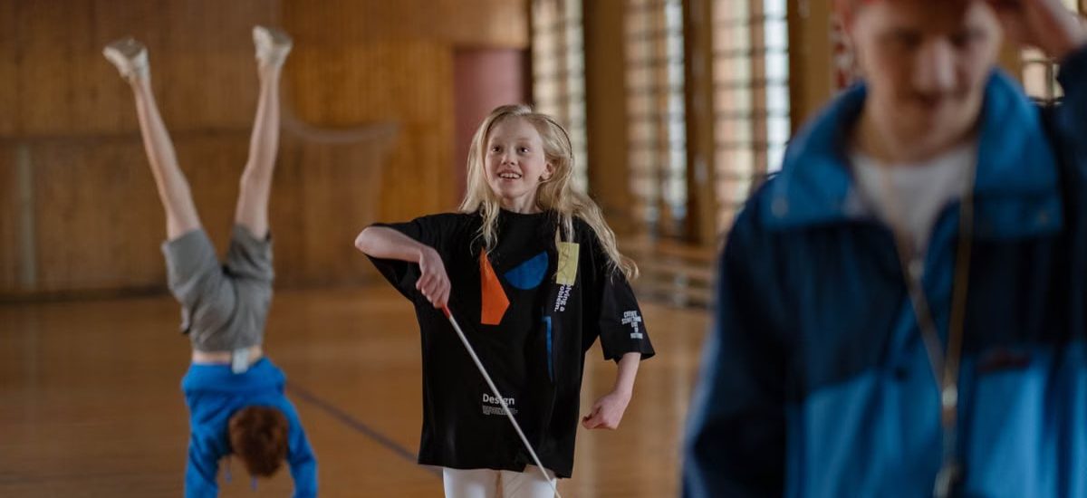 Children having fun in a school gym, with gymnastics and playful activities.