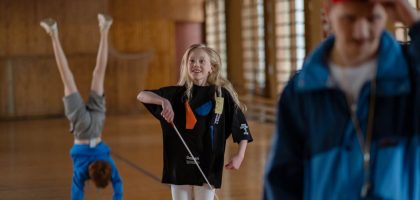 Children having fun in a school gym, with gymnastics and playful activities.