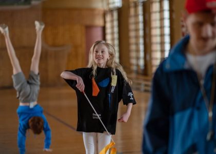 Children having fun in a school gym, with gymnastics and playful activities.
